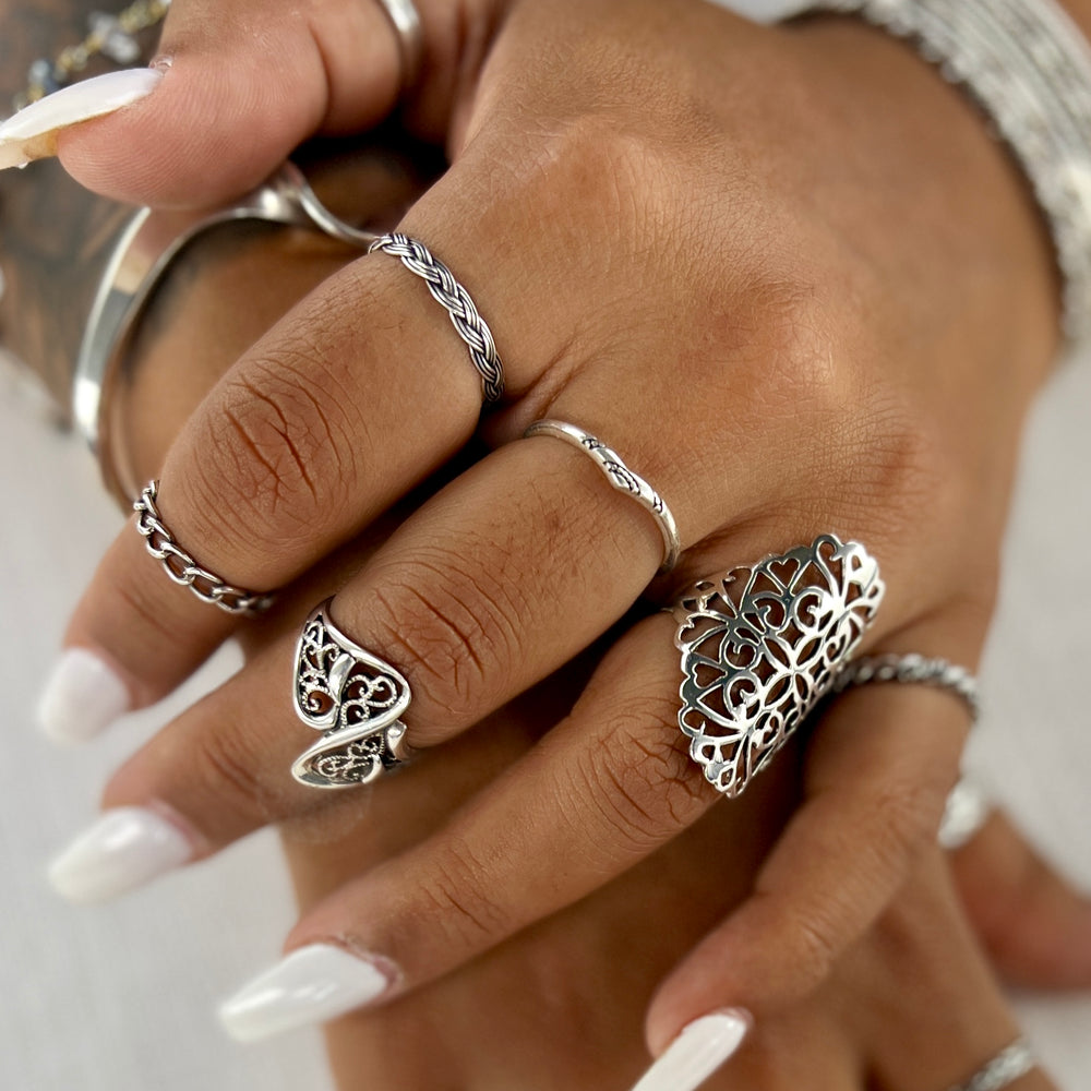 
                  
                    A woman's hands adorned with the Dainty Chevron Band With Etched Design, including a chic chevron design.
                  
                