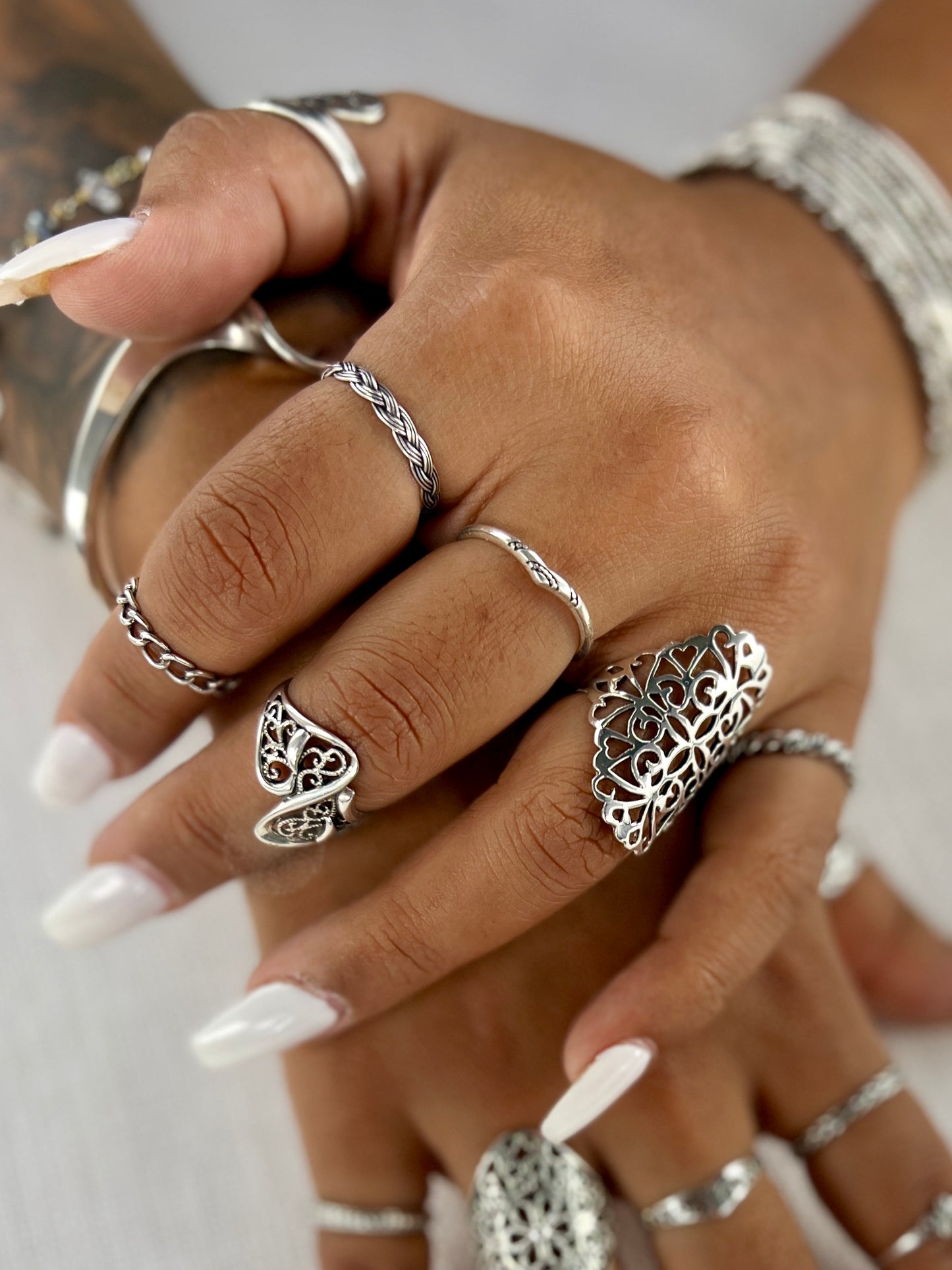 A woman's hands adorned with Super Silver's Chain Link Wire Rings featuring a chain link design.
