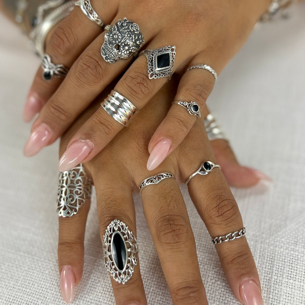 
                  
                    A woman's hands adorned with a Super Silver Diamond Shaped Filigree Ring with Inlaid Stones and a variety of rings, including lacy filigree and midi-rings.
                  
                