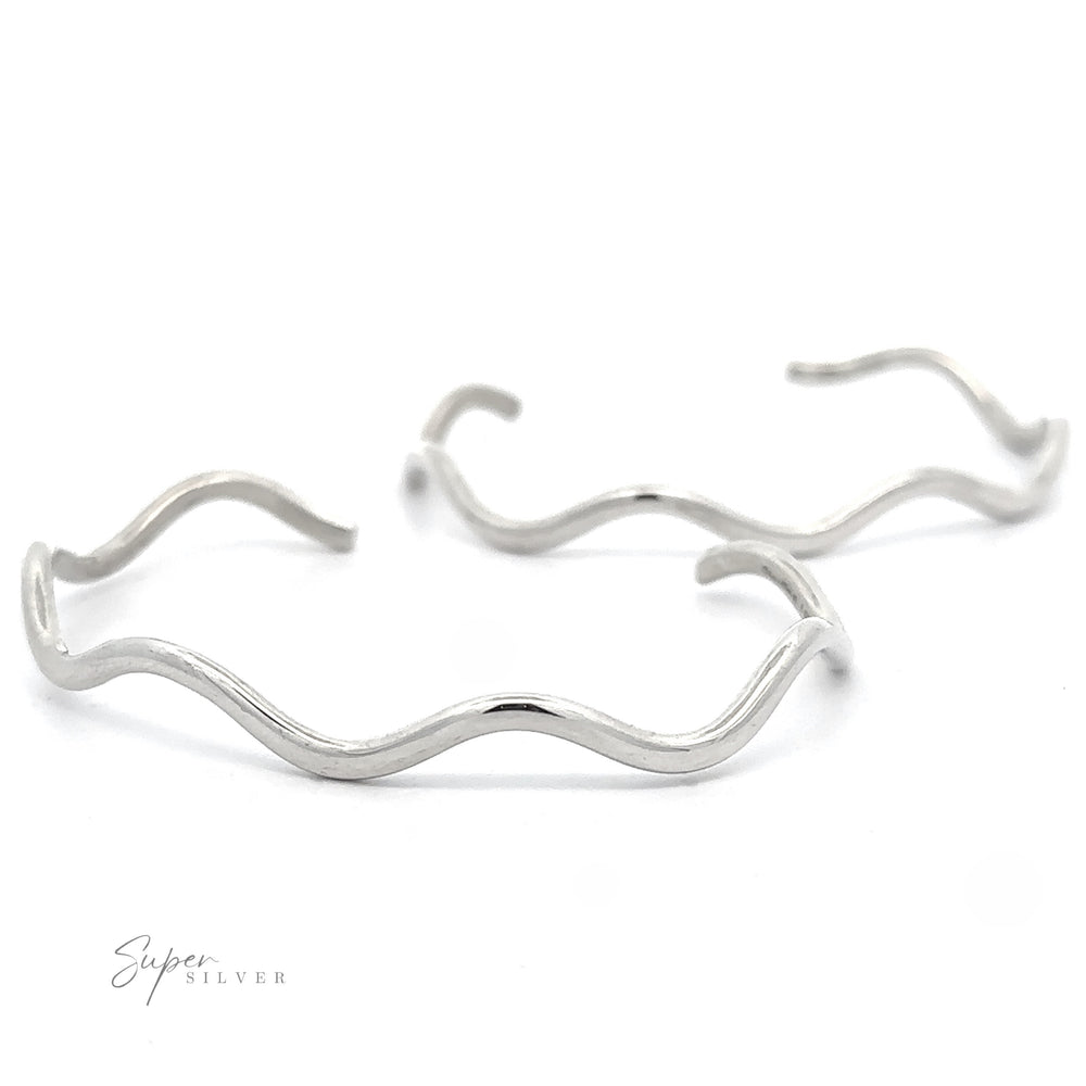 Two Native American Handmade Silver Wavy Cuff bracelets laid out against a white background. The phrase 