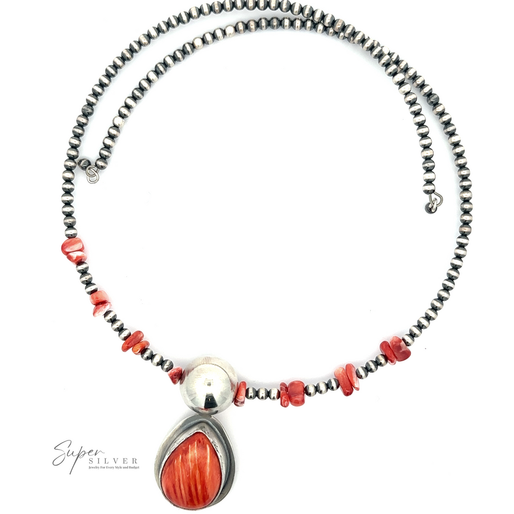 
                  
                    A Wrap Around Spiny Oyster Shell Choker Necklace featuring alternating Navajo pearls and red stones, with a teardrop-shaped pendant showcasing a red oval stone set in silver.
                  
                