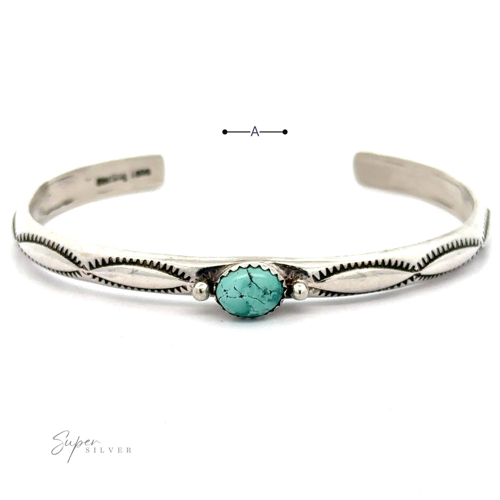 A handcrafted Striking Native American Turquoise Cuff with Diamond Etching featuring a central Kingman Turquoise stone and a decorative etched design in .925 sterling silver. The open-ended bracelet offers an exquisite touch of elegance.