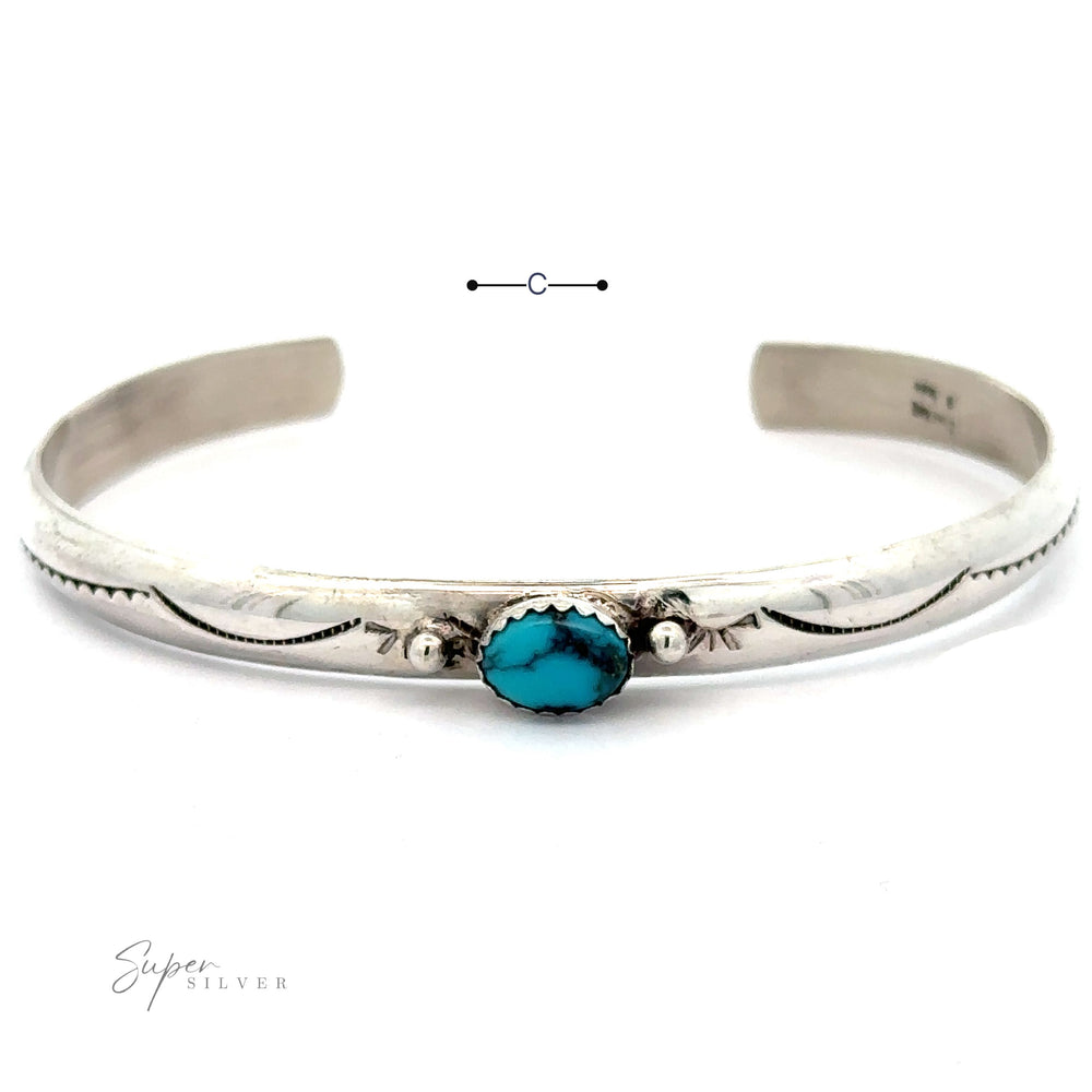 
                  
                    A Striking Native American Turquoise Cuff with Diamond Etching featuring a central oval Kingman Turquoise stone. The .925 Sterling Silver bracelet has engraved patterns on either side of the stone, with the brand name "Super Silver" displayed on the bottom left.
                  
                