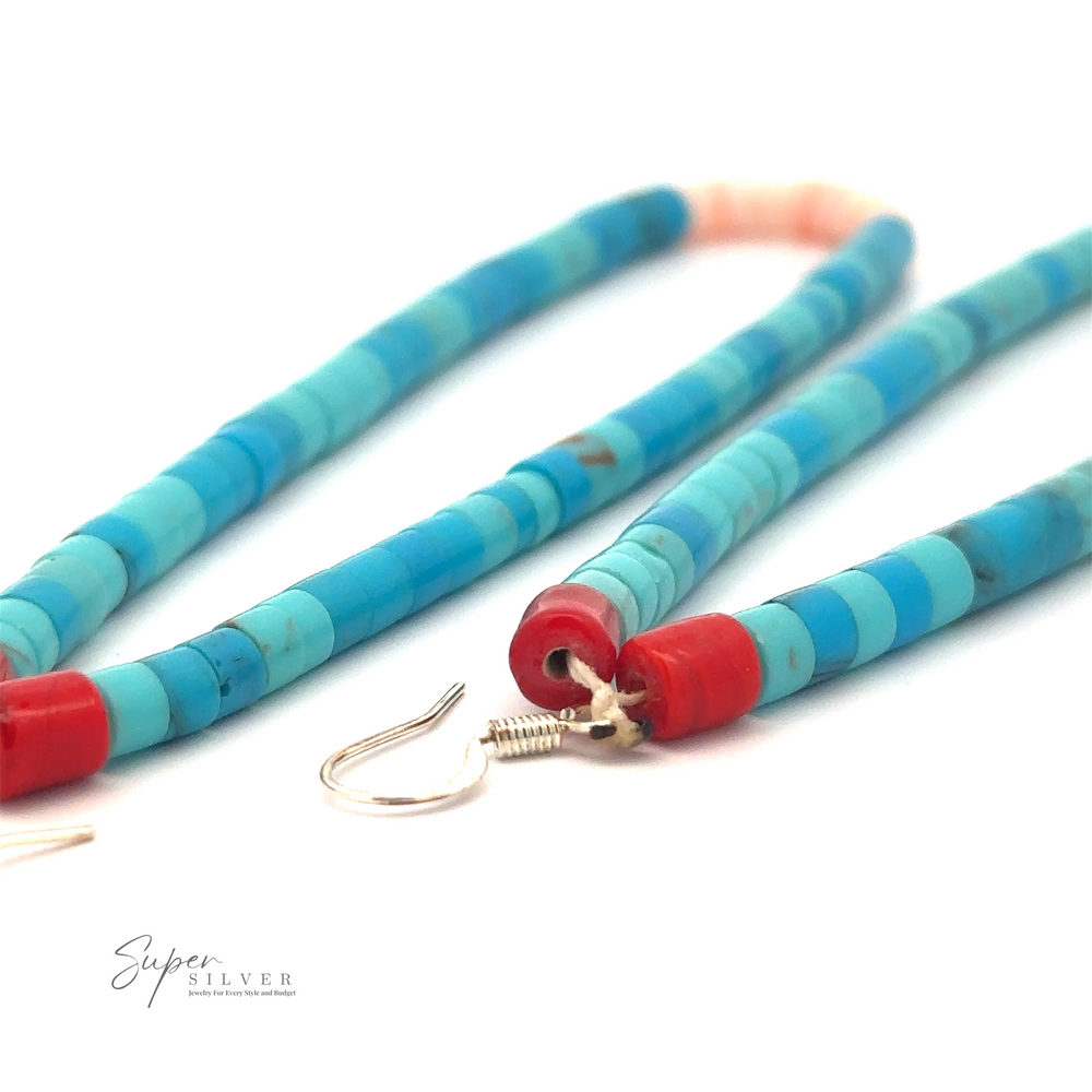 Close-up image of turquoise and red beaded jewelry lying flat on a white surface, with the text 