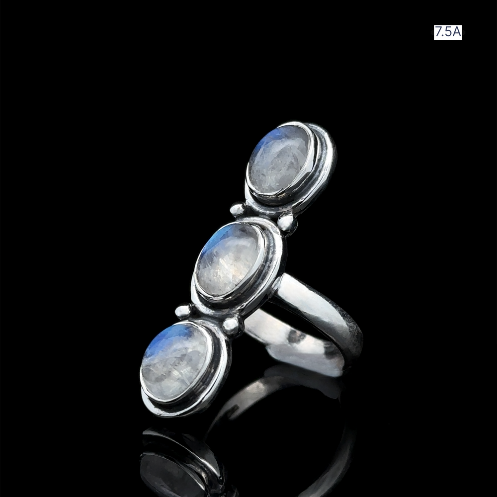 
                  
                    Triple Moonstone Ring crafted from sterling silver, featuring three vertically set oval moonstone cabochons on a black background, embodying the essence of goddess energy.
                  
                