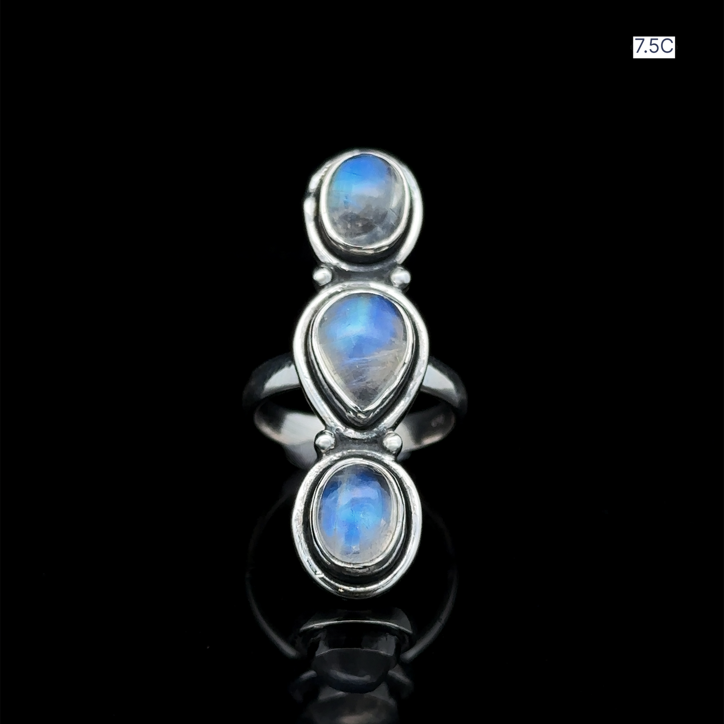 
                  
                    Triple Moonstone Ring crafted from sterling silver, featuring three moonstone gems arranged vertically against a dark setting, radiating goddess energy. Size 7.5C.
                  
                