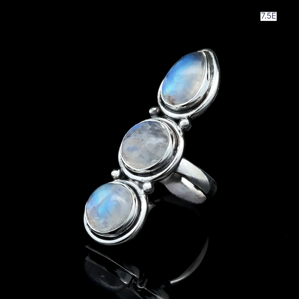 
                  
                    Triple Moonstone Ring crafted from sterling silver, featuring three oval moonstone gemstones elegantly set against a striking black background. Size 7.5. It exudes goddess energy.
                  
                