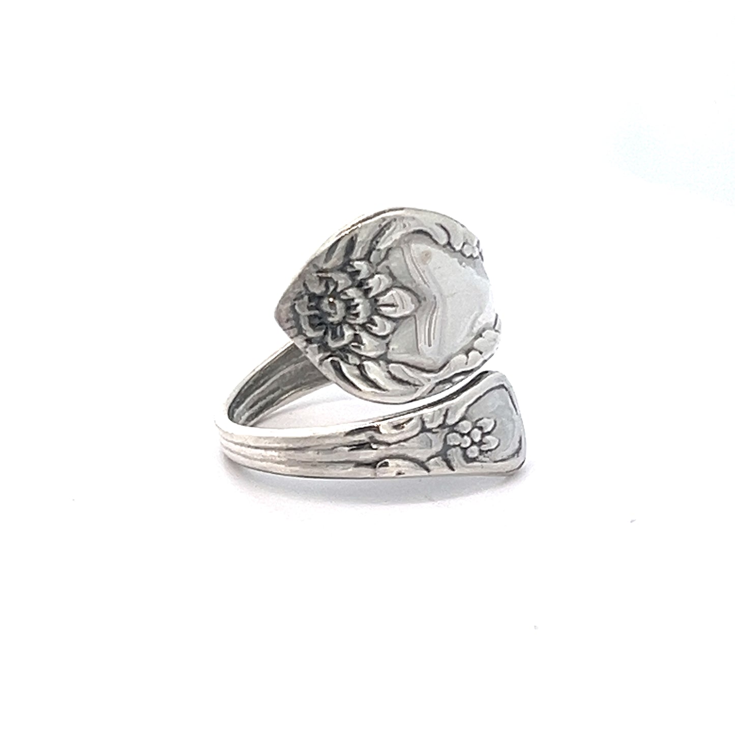 
                  
                    A Timeless Spoon Ring made from .925 Sterling Silver, showcasing intricate floral engravings and a wrap-around design.
                  
                