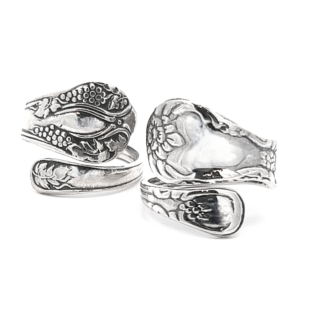 Two Timeless Spoon Rings featuring intricate designs, resembling snake-like patterns, with one ring forming a loop around itself. Made from .925 Sterling Silver.