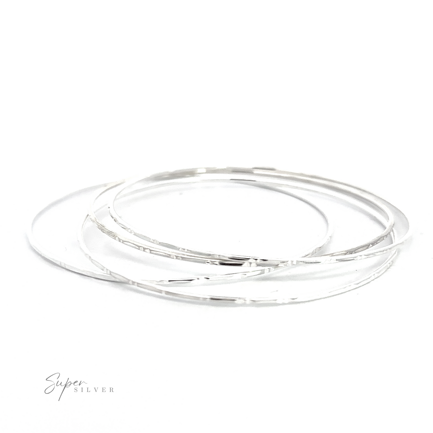 
                  
                    Three Sparkling Faceted Bangle Bracelets on a white surface.
                  
                