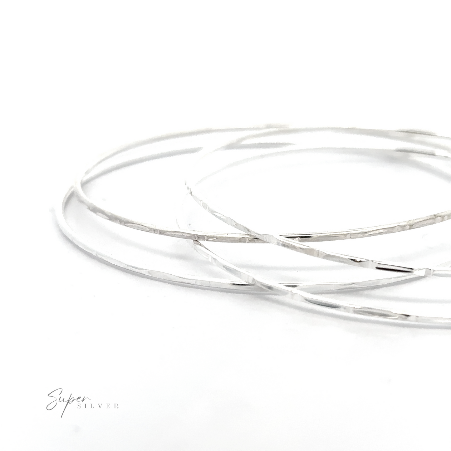 
                  
                    Three Sparkling Faceted Bangle Bracelets with a minimal vibe on a white surface.
                  
                