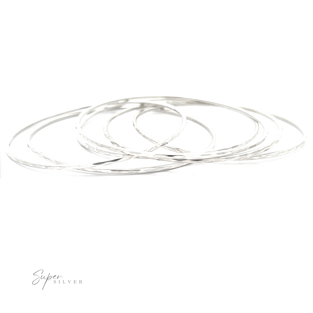 
                  
                    A stack of Elegant Faceted Bangle Bracelets on a white background, sparkling delicately.
                  
                