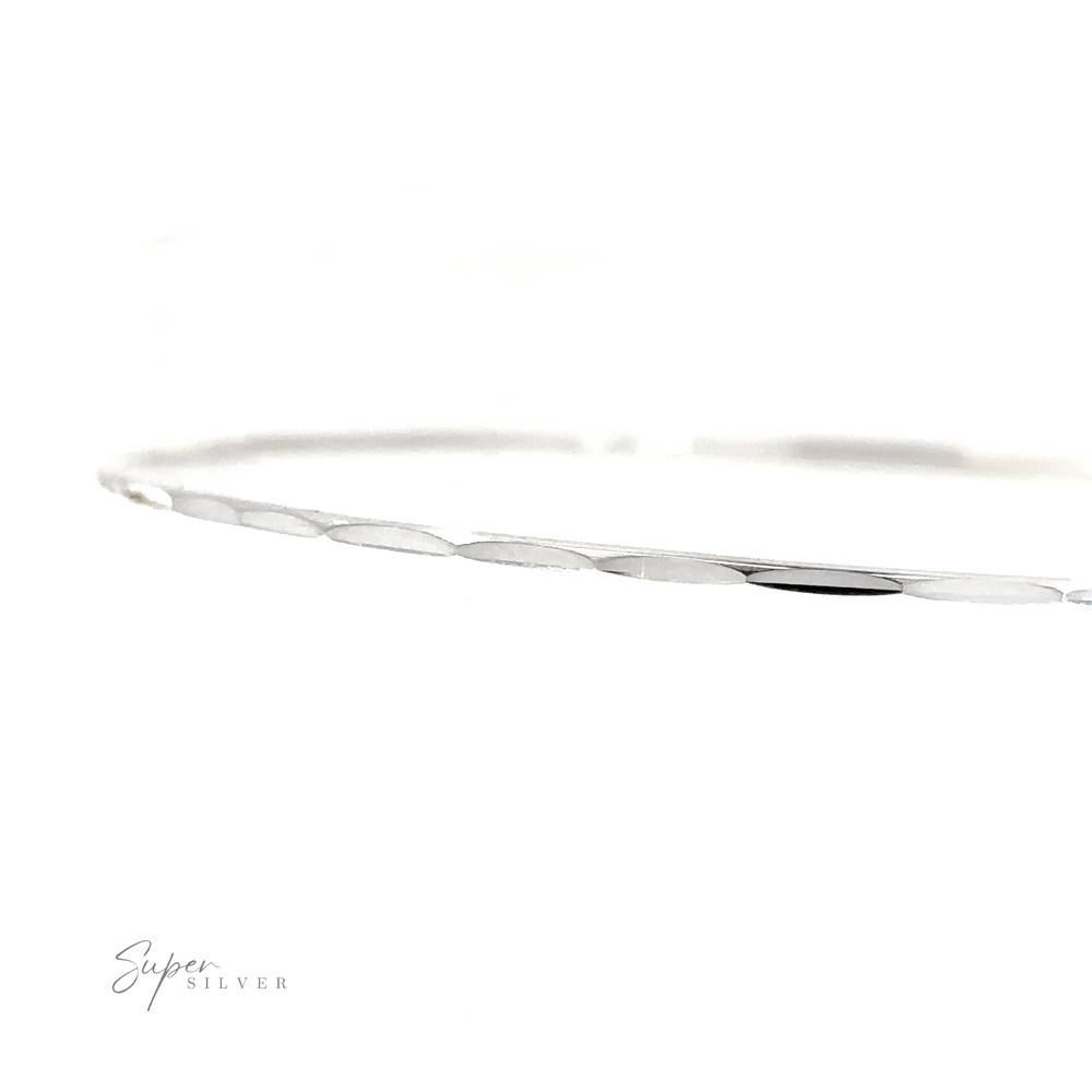 
                  
                    A Dainty Faceted Silver Bangle bracelet on a white background.
                  
                