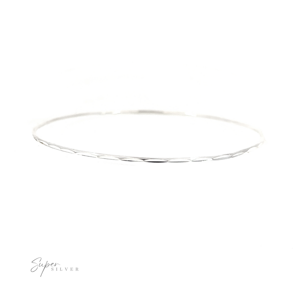 
                  
                    A Dainty Faceted Silver Bangle bracelet on a white background, made of .925 Sterling Silver.
                  
                