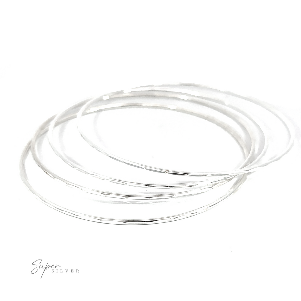 
                  
                    A stack of Dainty Faceted Silver Bangles on a white background.
                  
                