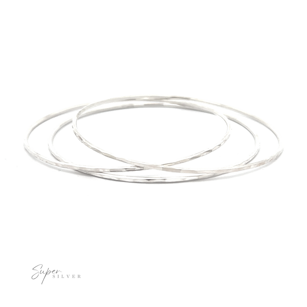 
                  
                    Three Faceted Silver Bangle Bracelets on a white background.
                  
                