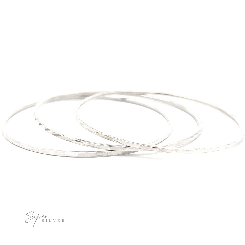 
                  
                    Three Faceted Silver Bangle Bracelets crafted from .925 Sterling Silver on a white background.
                  
                