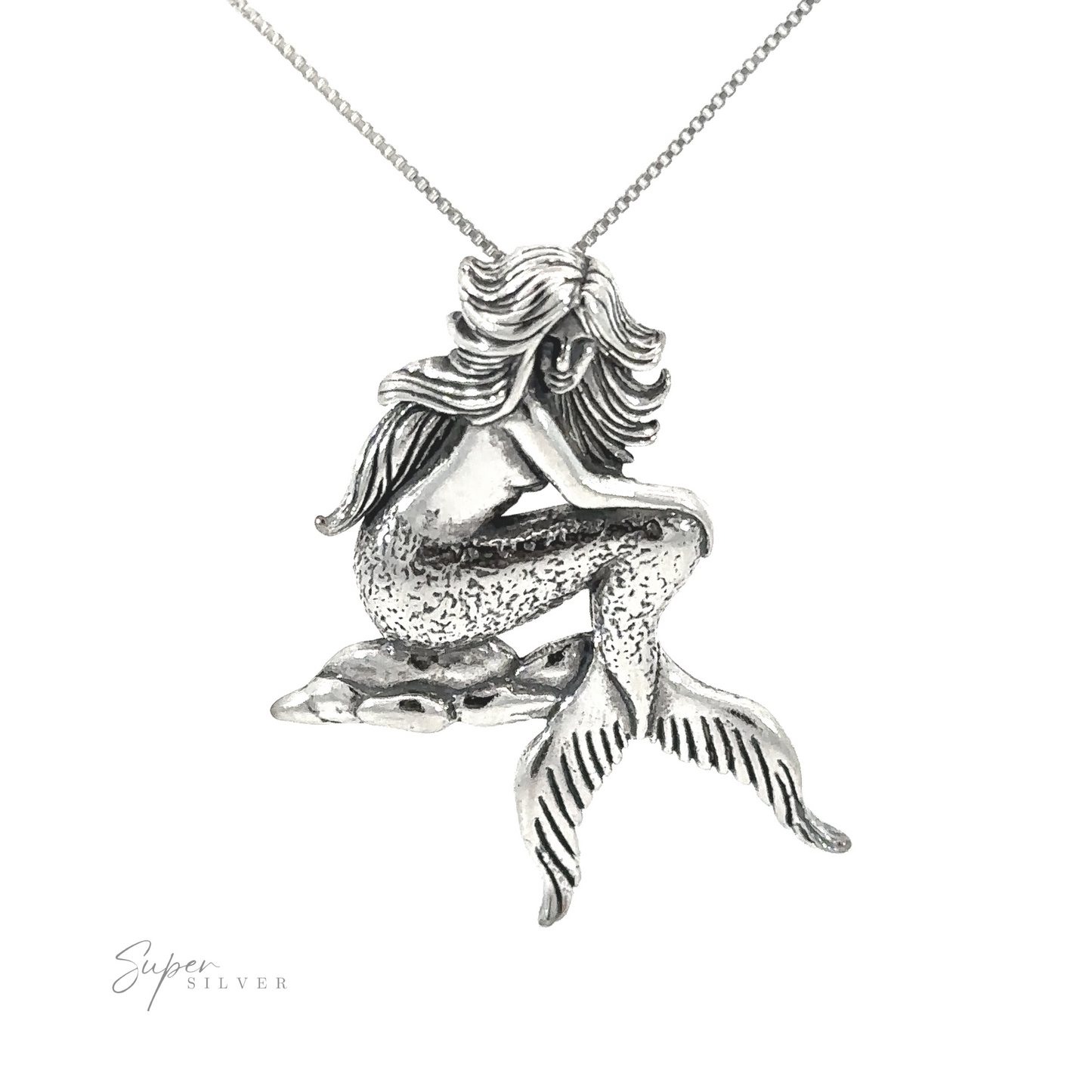 An enchanting Seductive Mermaid Pendant featuring a silver mermaid gracefully perched on a rock.