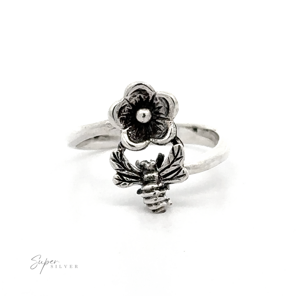 A Silver Bee and Flower Ring adorned with a delicate flower and a bee in mid-flight, perfect for nature lovers.