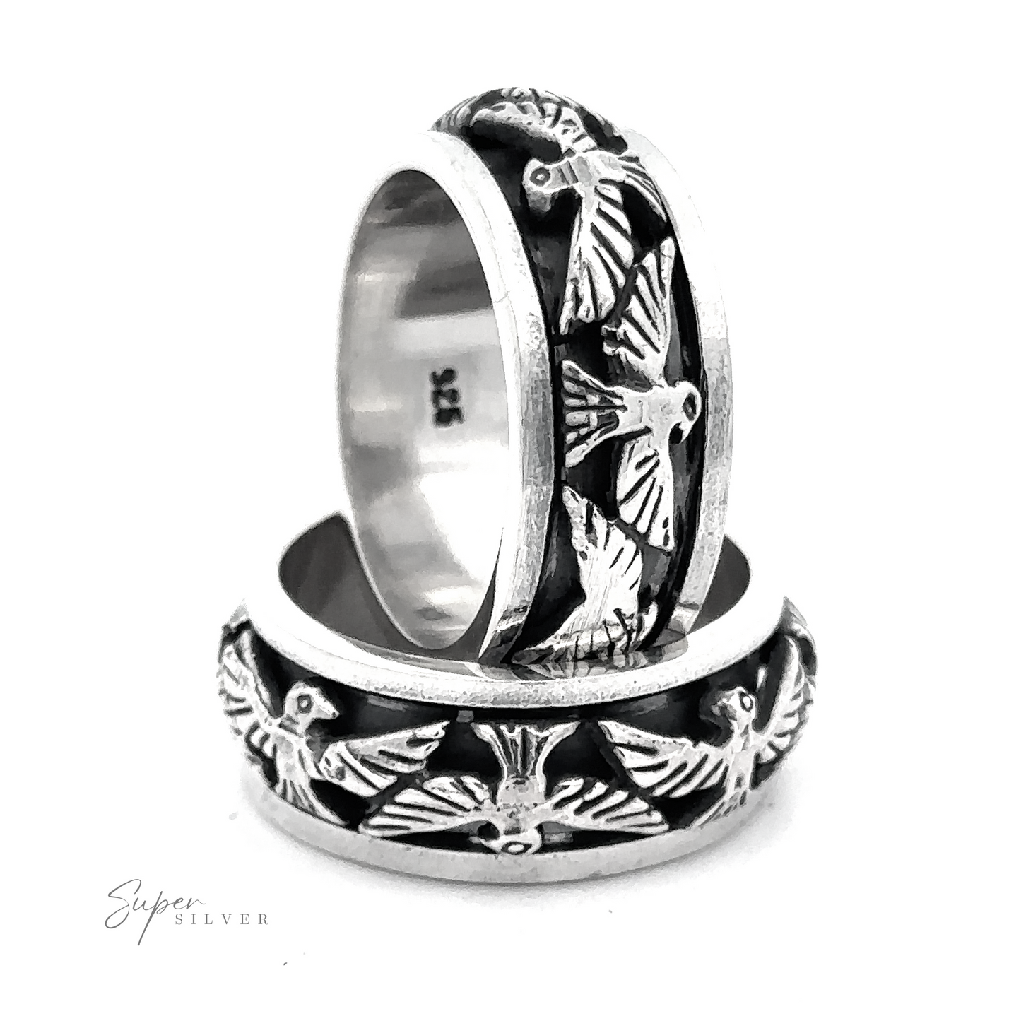 
                  
                    Two silver rings with intricate thunderbird engravings on the bands are stacked against a white background. The words "Thick Thunderbird Spinner Ring" appear in the lower left corner.
                  
                