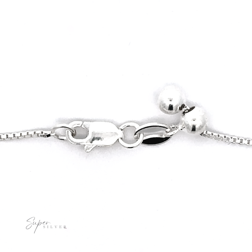 
                  
                    A close-up image of the clasp on an Adjustable Silver Box Chain, made from Sterling silver and featuring two silver beads along with an engraved label reading "Super Silver.
                  
                