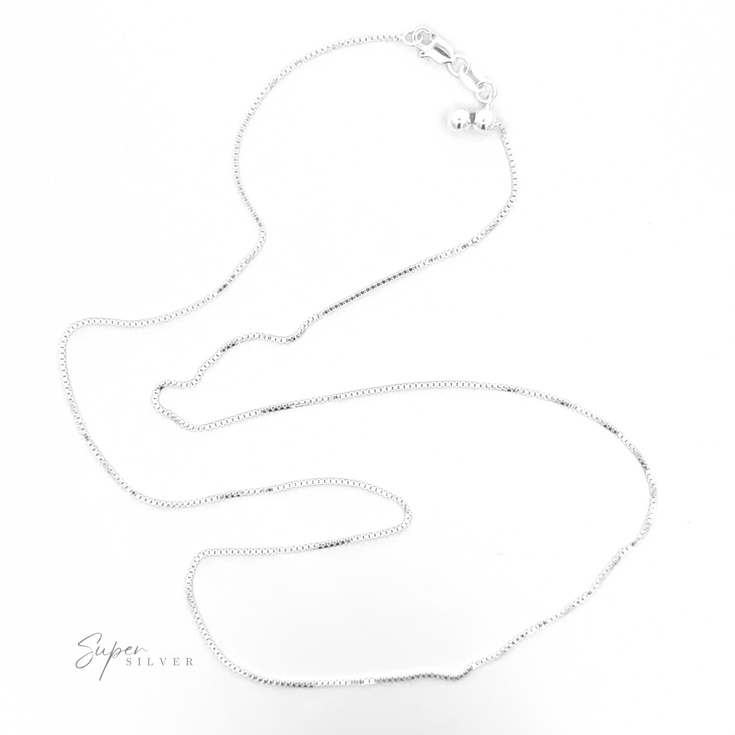 
                  
                    An elegant piece, the Adjustable Silver Box Chain, is showcased against a pristine white background, featuring a small round clasp at one end. This versatile necklace has an adjustable length, making it ideal for layering with other pieces. The brand name "Super Silver" is subtly displayed in the lower left corner.
                  
                