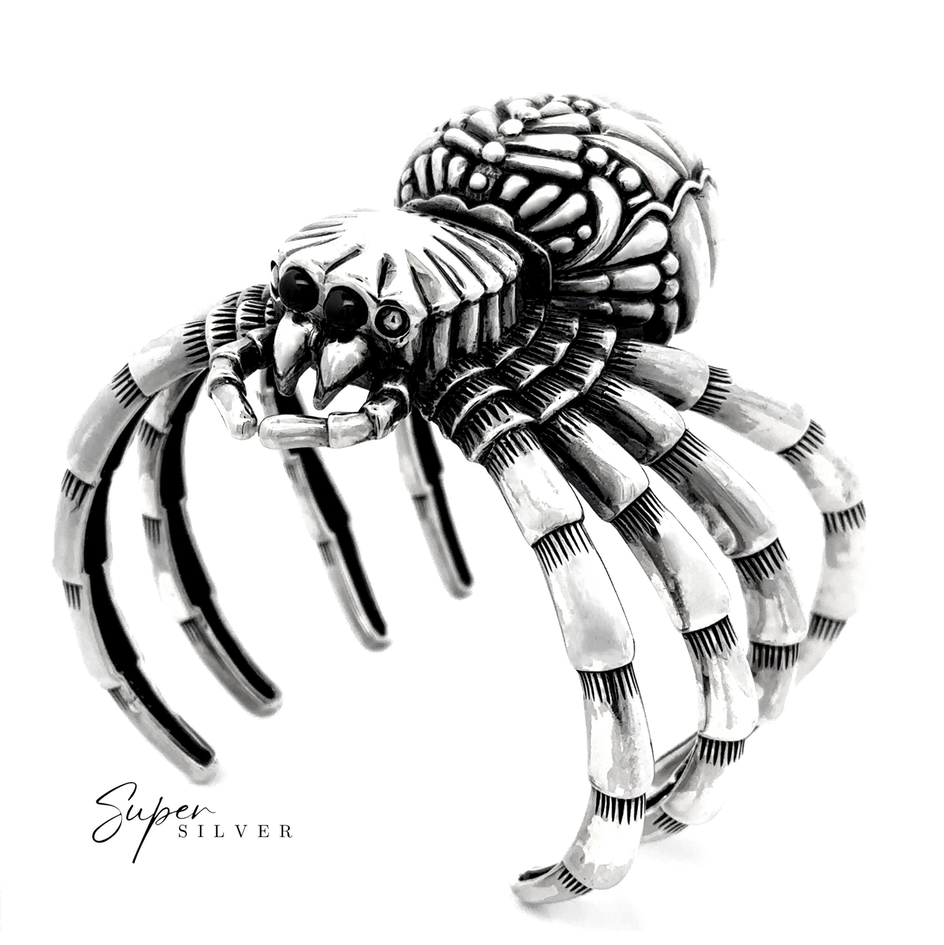 The Witch Weaver Spider Cuff is a silver bracelet with segmented legs and a textured body, creating a bold statement piece. The "Super Silver" logo is featured in the lower left corner.
