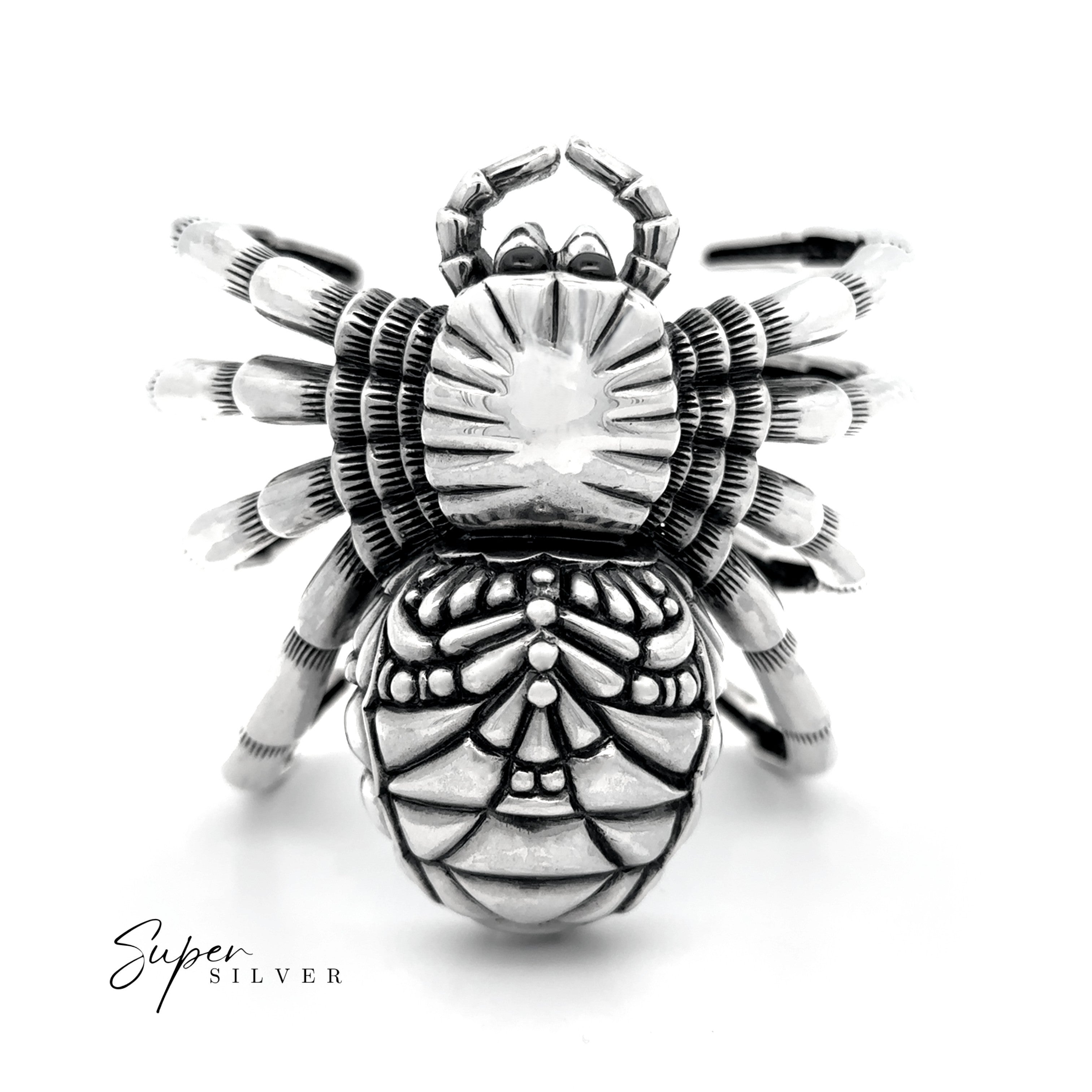 The Witch Weaver Spider Cuff, a sterling silver ring with intricate spider patterns, is centered on a white background. "Super Silver" is displayed in the lower left corner, highlighting this statement jewelry piece.