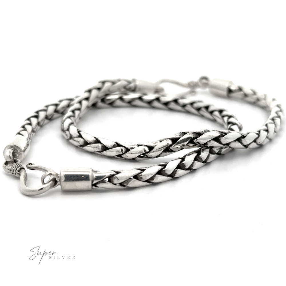 A 4mm Bright Rope Bracelet with a lobster clasp lies coiled on a white background, perfect for everyday and stacking. 