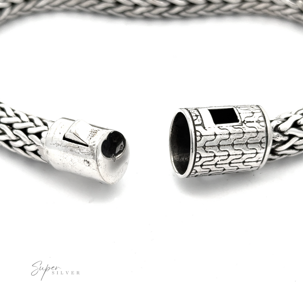 Close-up of an open clasp on a Heavy Braided Bracelet with intricate woven design, displaying detailed metalwork and a hidden connection mechanism. The words "Super Silver" are visible in the bottom left corner.
