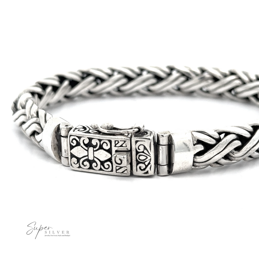 Intricately woven Heavy Double Strand Braided Bracelet with detailed clasp and design elements. This heavy braided bracelet is a true statement piece. Logo in the bottom left corner reads 