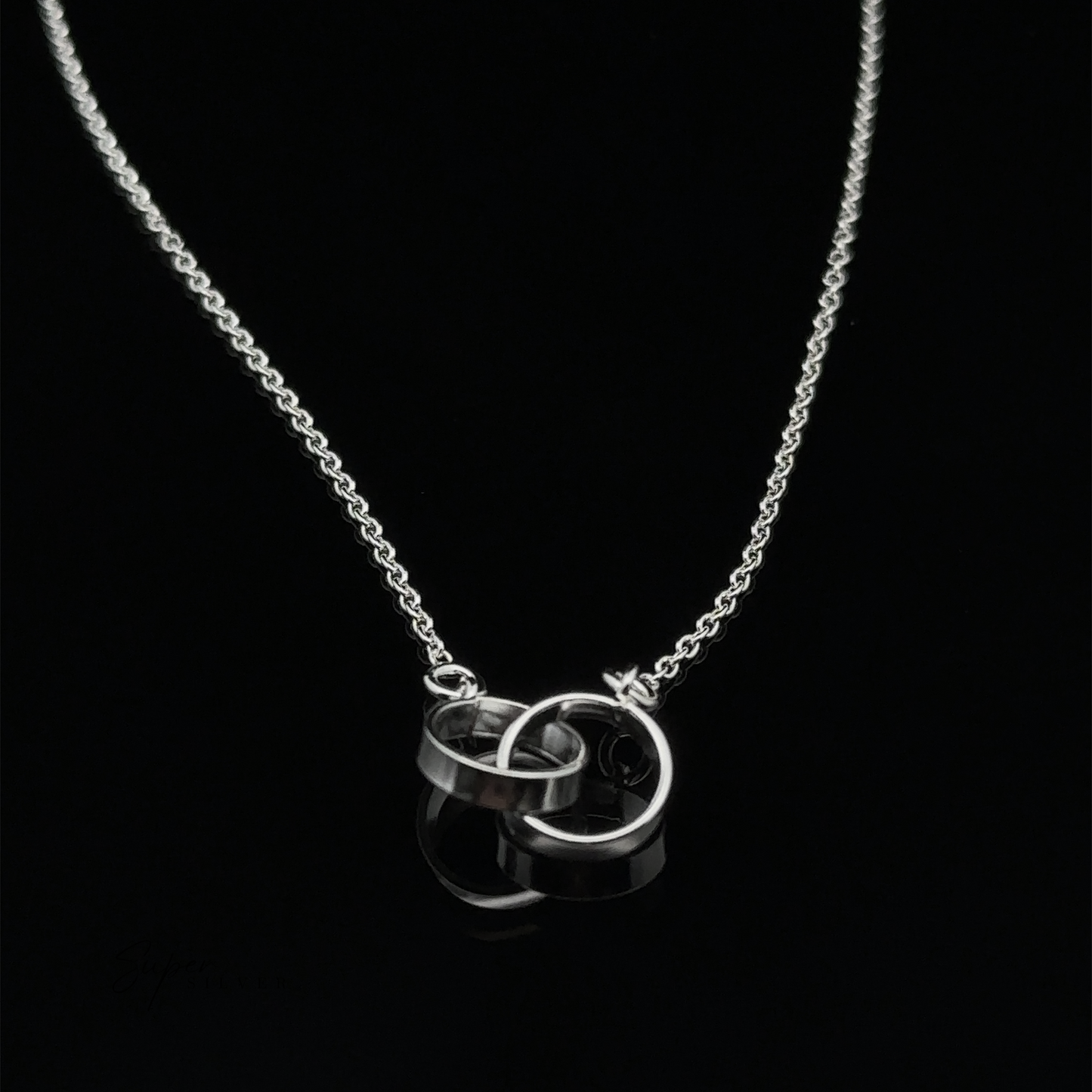 
                  
                    A Double Circle Necklace featuring two interlocking rings as a pendant, displayed on a black background.
                  
                