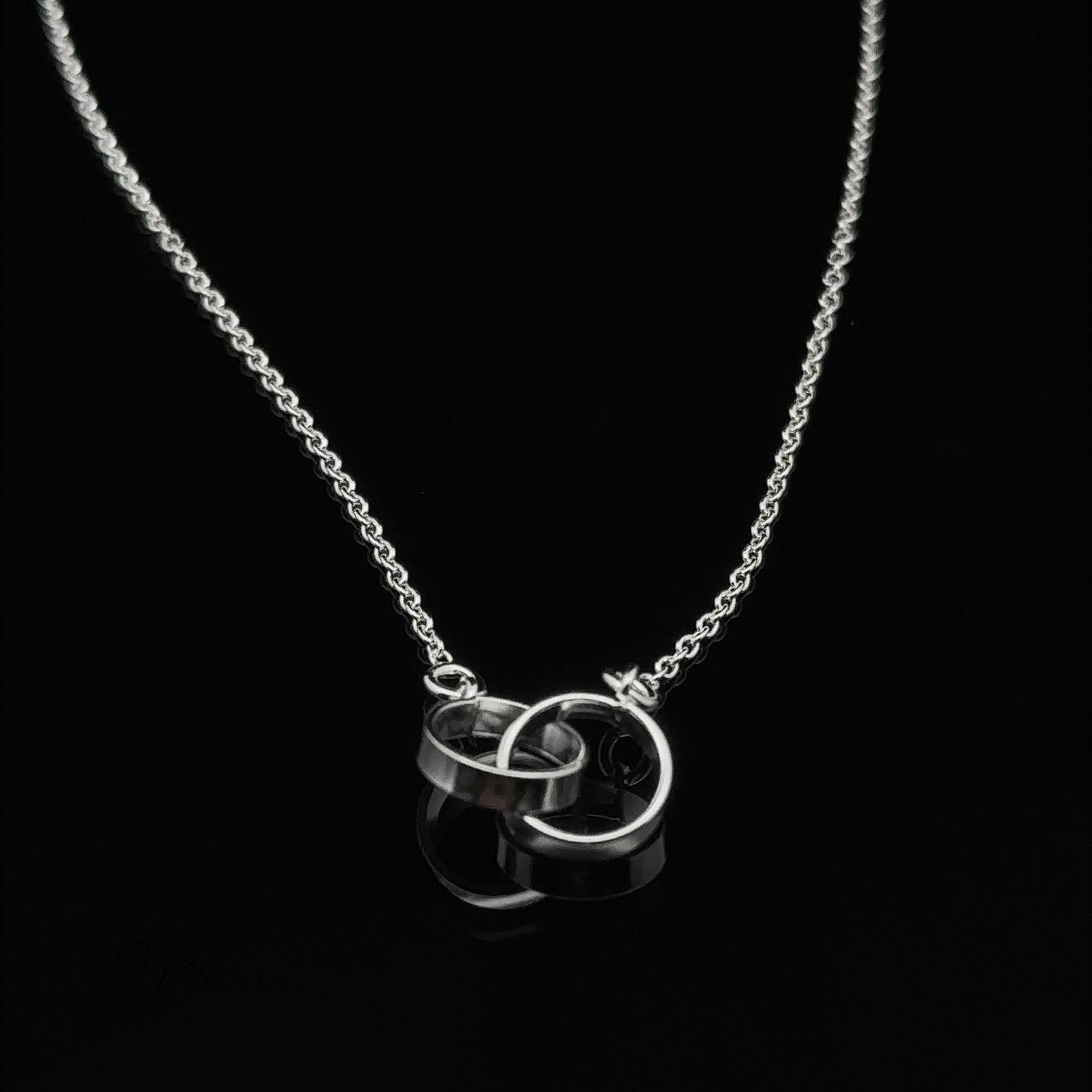 A Double Circle Necklace featuring two interlocking rings as a pendant, displayed on a black background.