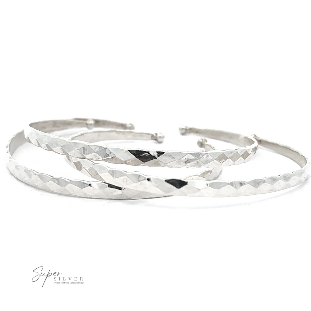 
                  
                    A set of three thin, textured silver bangles, crafted from .925 Sterling Silver, placed on a white surface. The Stackable Hammered Cuff boasts a geometric pattern, adding a sophisticated touch. The lower left corner shows the text "Super Silver".
                  
                