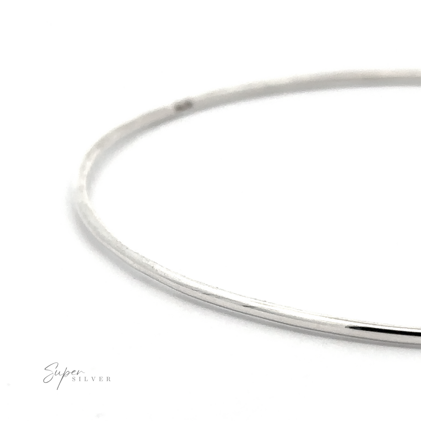 Close-up of a thin, plain silver Plain Bangle set against a pristine white background. "Super Silver" is written in small text in the bottom left corner, highlighting this versatile accessory.