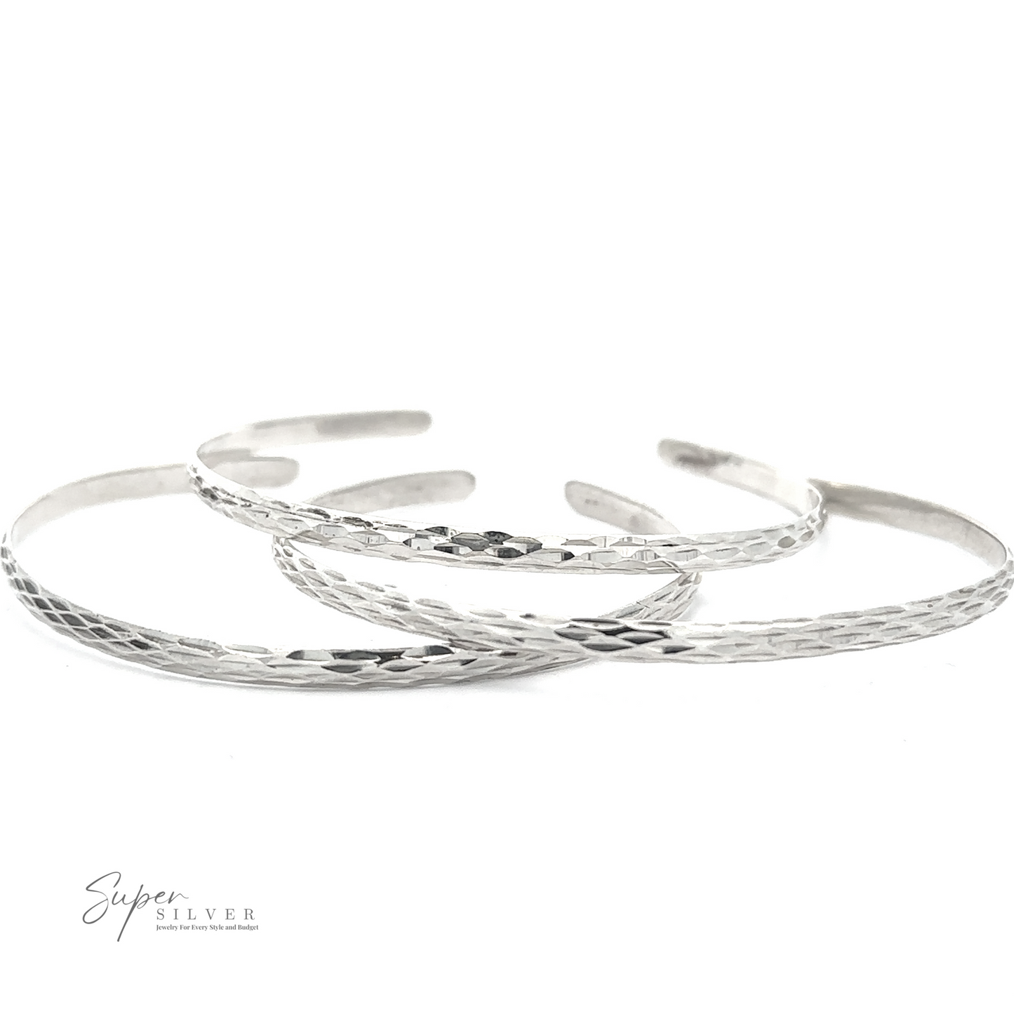 
                  
                    Three overlapping, thin, sterling silver bracelets with a textured pattern. The logo “Glittering Diamond Cut Cuff Bracelet” is displayed in the bottom left corner. These minimalist bracelets offer a subtle elegance perfect for any occasion.
                  
                