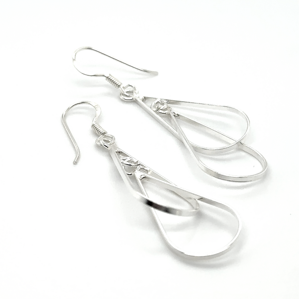 
                  
                    A pair of Super Silver Double Wire Teardrop Earrings with a swinging teardrop shape, placed on a white surface.
                  
                