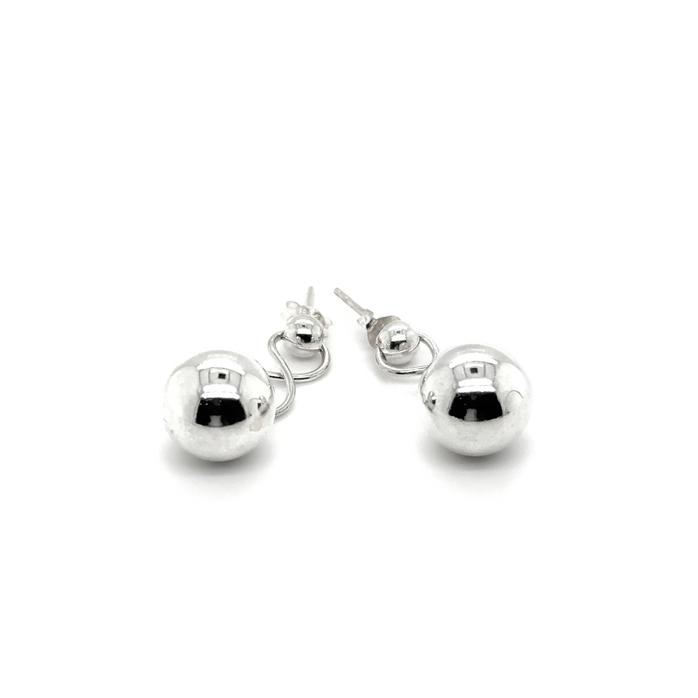 
                  
                    A pair of Super Silver Dangly Silver Ball Earrings attached by an infinity loop on a white background.
                  
                