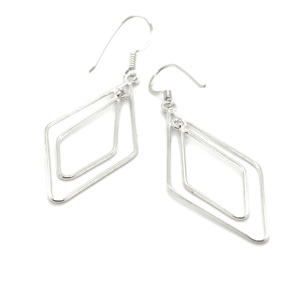 
                  
                    A pair of Super Silver diamond shaped earrings with geometric shapes.
                  
                