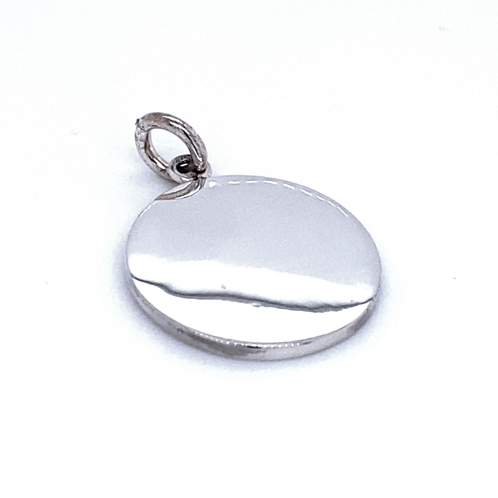 A Simple Round Engravable Pendant with a small, attached loop for a chain or cord. The pendant has a smooth, reflective surface and is photographed against a plain, white background. This customizable jewelry piece can be engraved to create a personalized touch.
