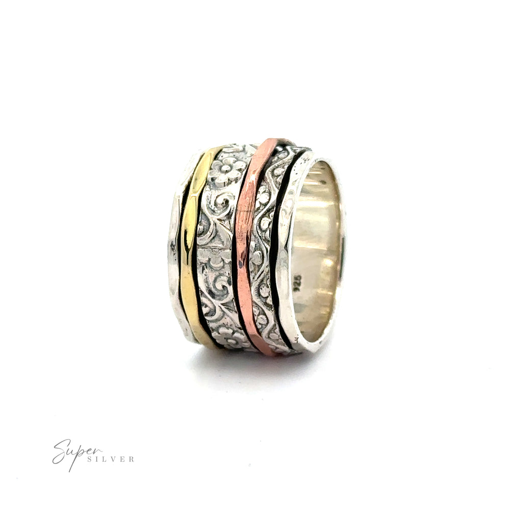 A Handmade Spinner Band with Flower Etching with a spiral design featuring gold and copper bands.