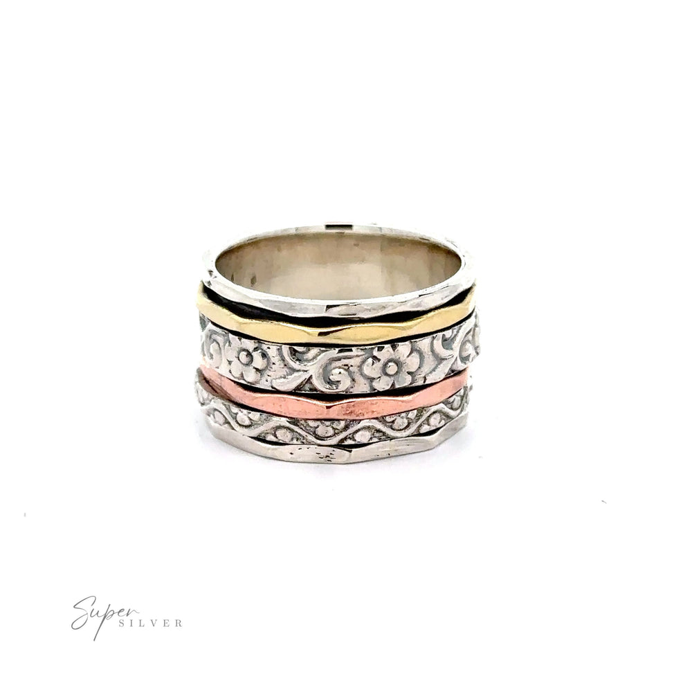 
                  
                    A Handmade Spinner Band with Flower Etching with an etched floral pattern on silver and gold bands.
                  
                