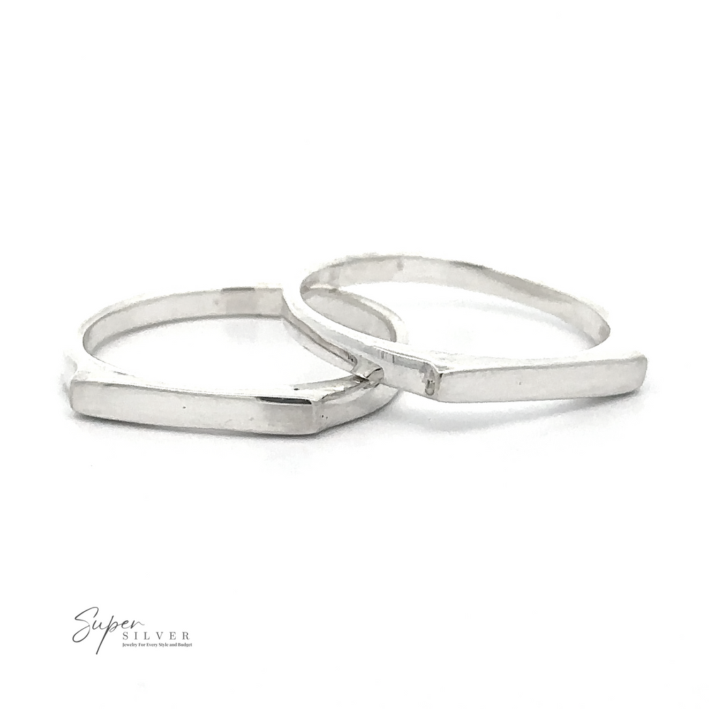 Two Dainty Silver Bar Rings with a geometric design are displayed against a white background. Embracing modern minimalism, the logo 