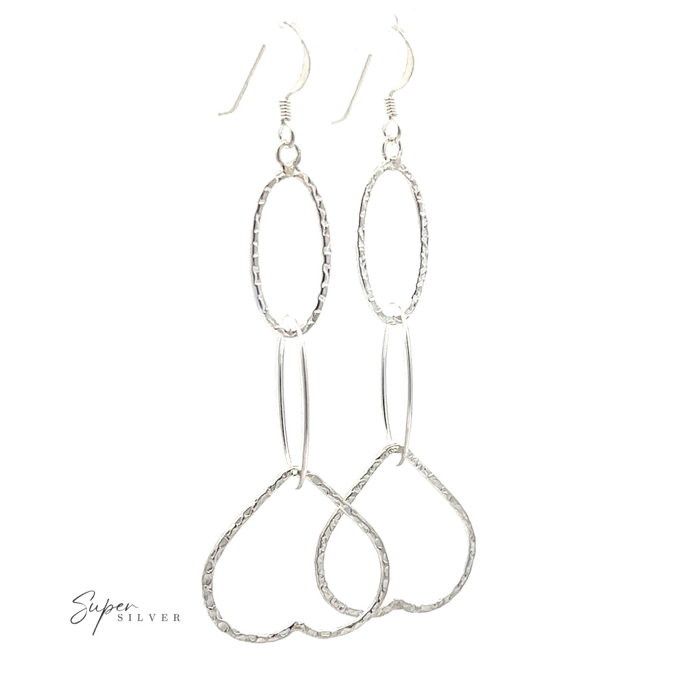 A pair of long silver Hammered Three Tiered Heart dangle earrings, set against a white background.