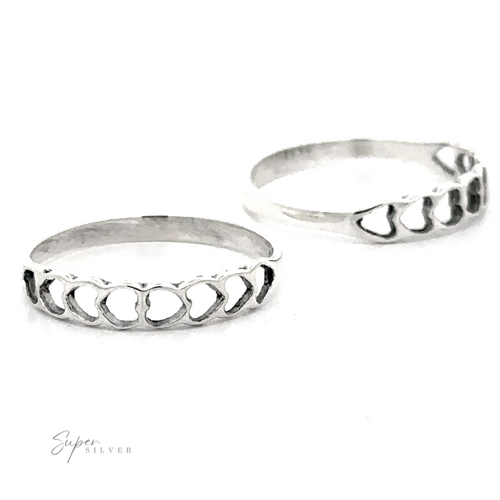 Two Delicate Heart Cutout Band rings in sterling silver on a white background, one ring slightly behind the other with a subtle shadow.