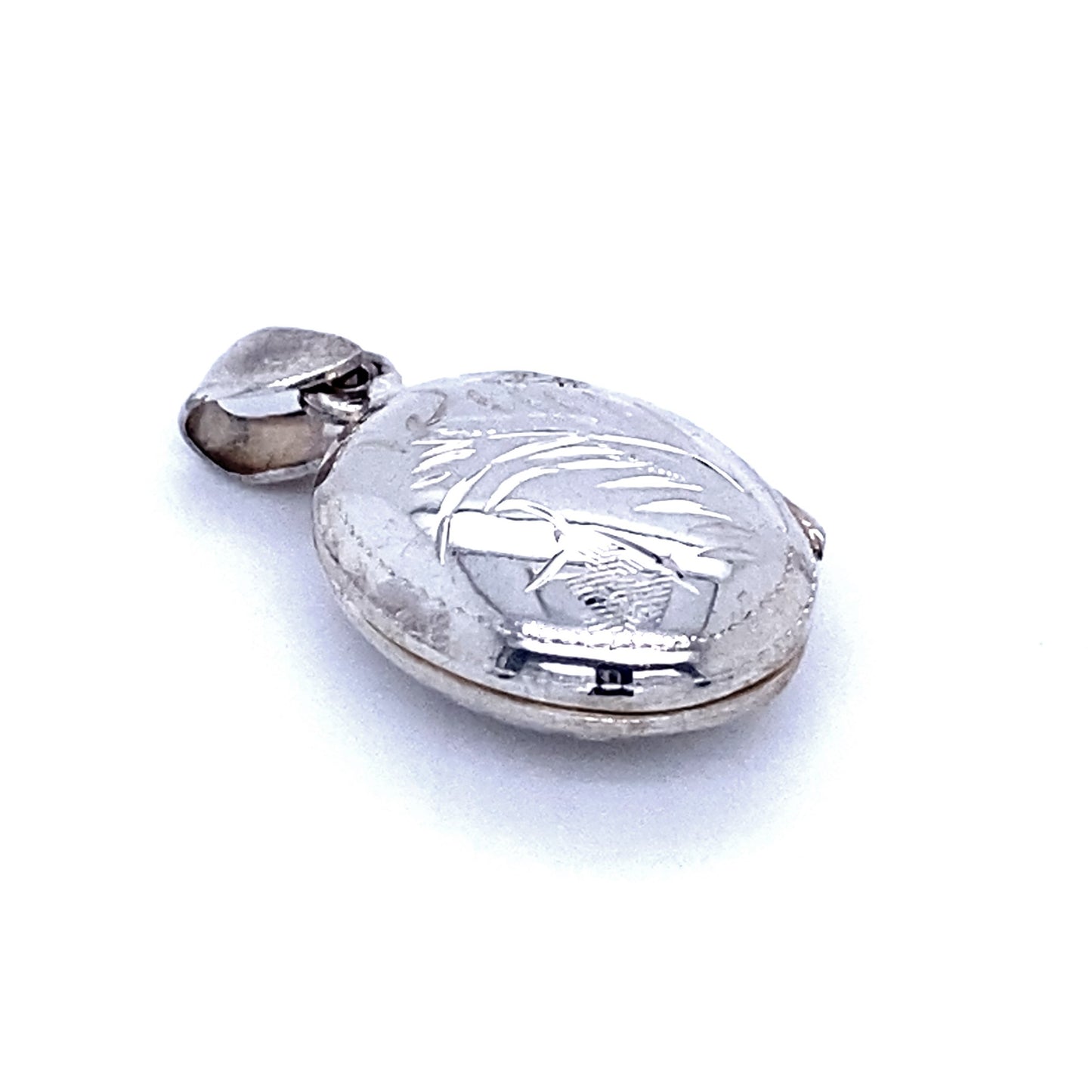
                  
                    A close-up image of a sterling silver pendant in the form of an Oval Locket with Plant Etching. The Victorian locket features a hinged lid and a small attached loop for a chain.
                  
                
