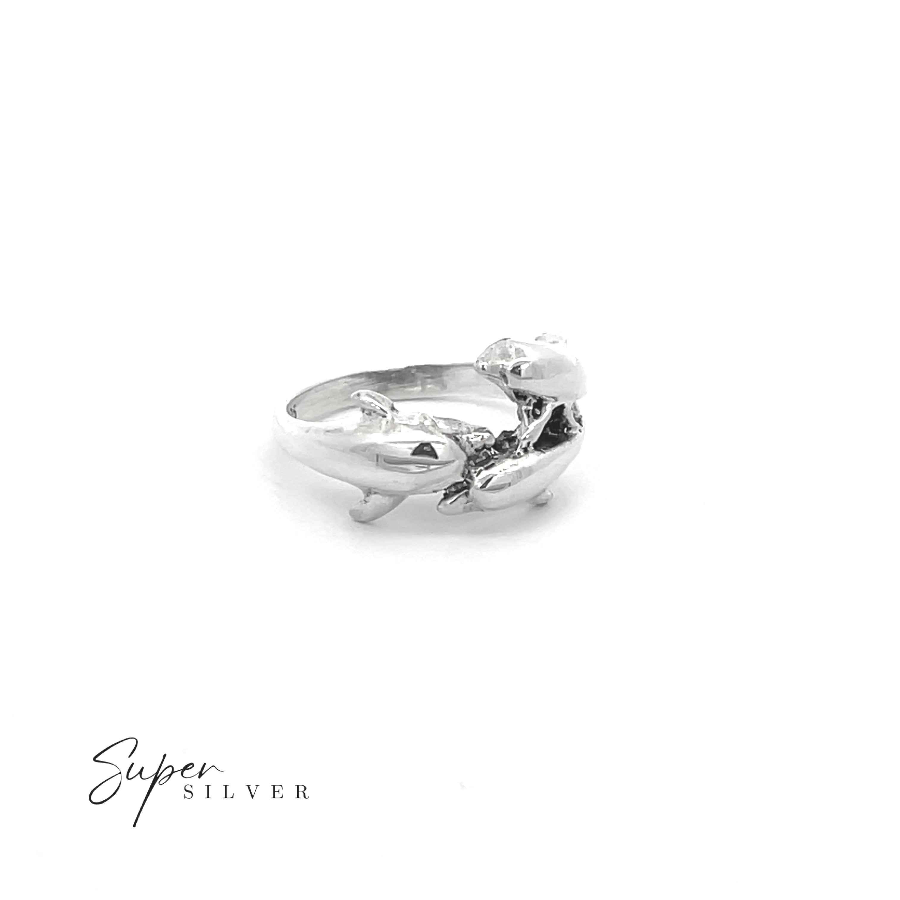 The Dolphin Pod Ring is a sterling silver ring featuring two dolphins facing each other, displayed on a white background with "Super Silver" in the corner—an ideal piece for ocean lovers and jewelry enthusiasts.