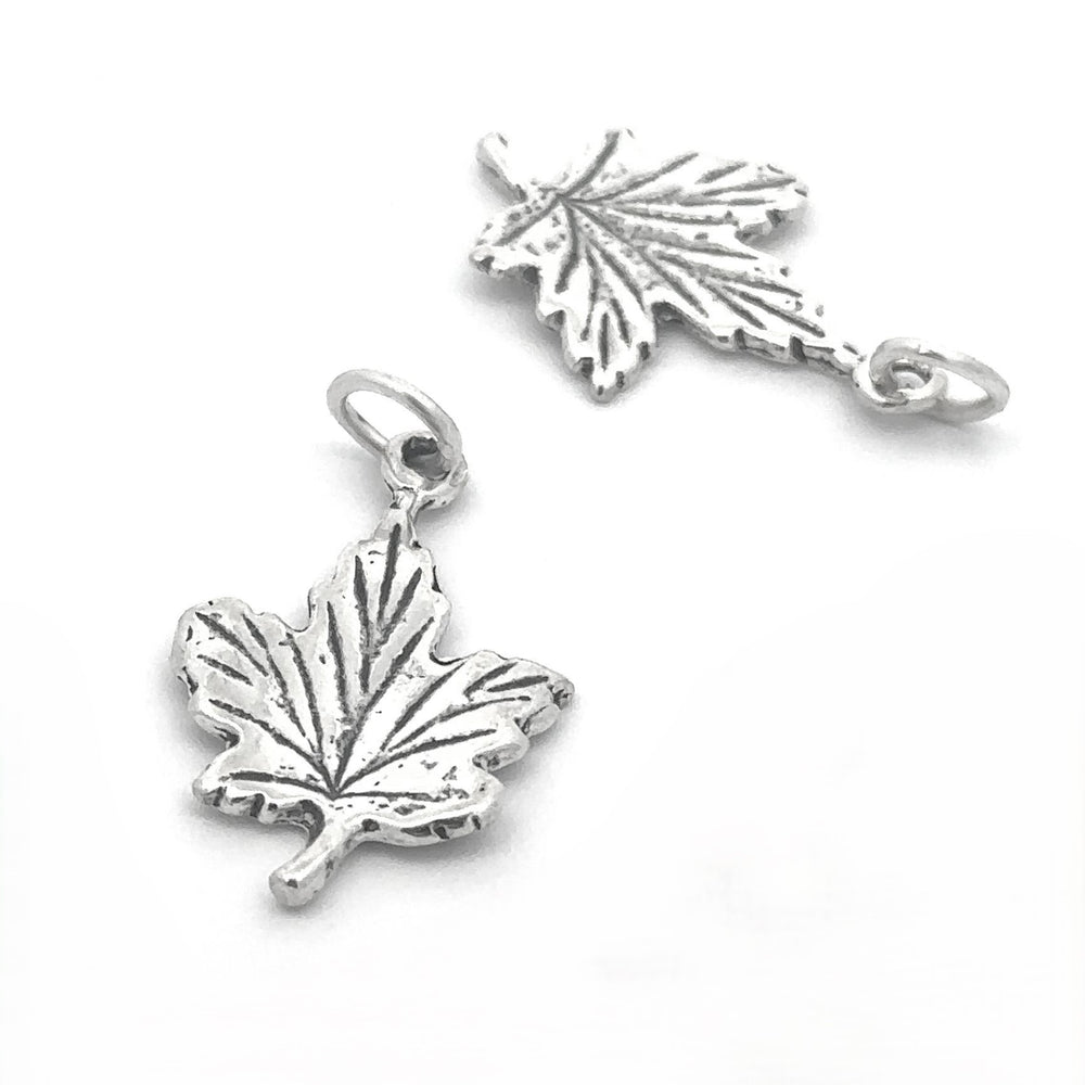 Add a touch of autumn style to any accessory with two Tiny Maple Leaf Charms, crafted in sterling silver and featuring intricate vein patterns and a small loop for easy attachment.