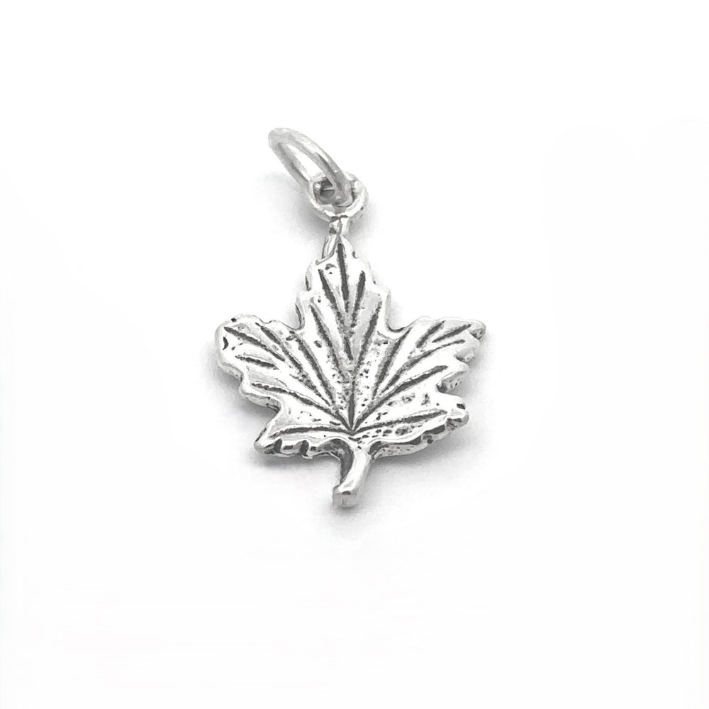 Tiny Maple Leaf Charm crafted in sterling silver features a ridged texture and a small loop for attaching to a chain, capturing an elegant autumn style.