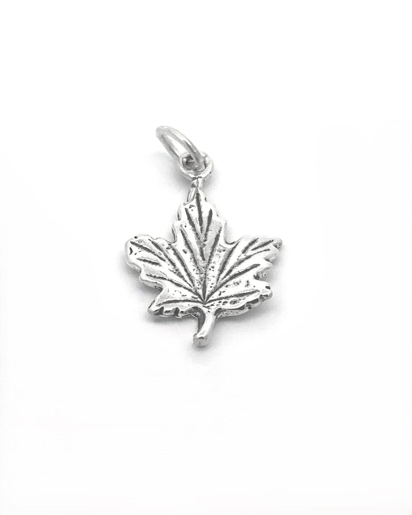 
                  
                    Tiny Maple Leaf Charm crafted in sterling silver features a ridged texture and a small loop for attaching to a chain, capturing an elegant autumn style.
                  
                